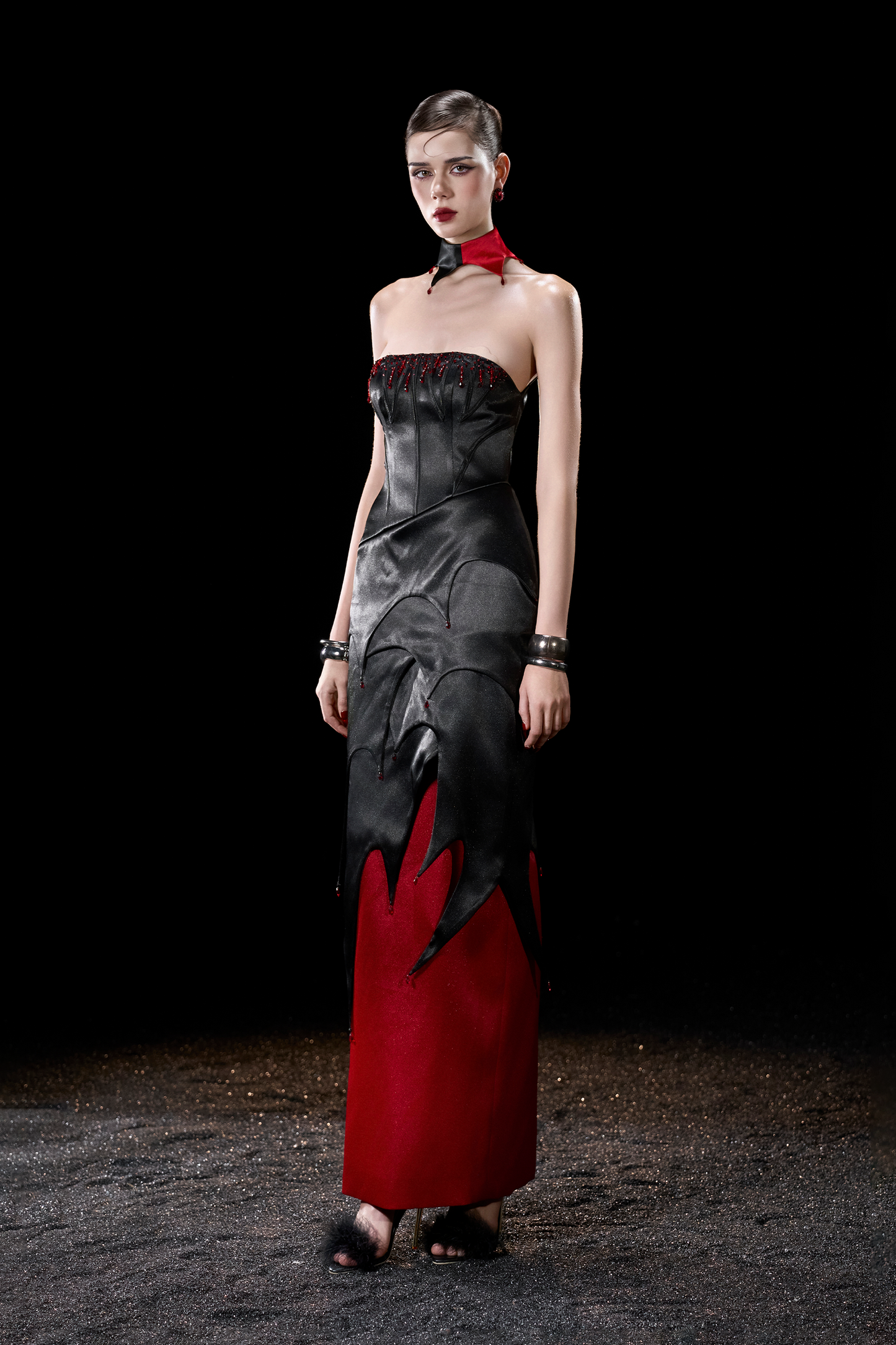 Model wearing a strapless dress with black and red design