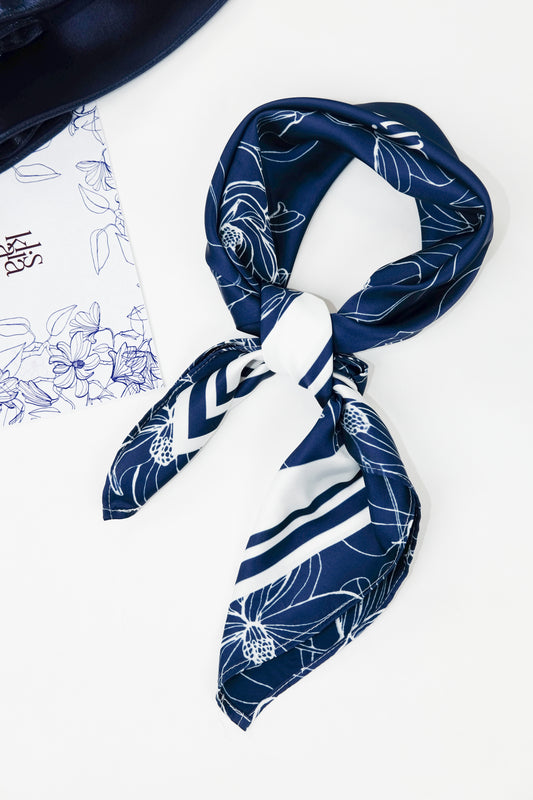 Blue and white floral silk scarf tied with a simple front knot.