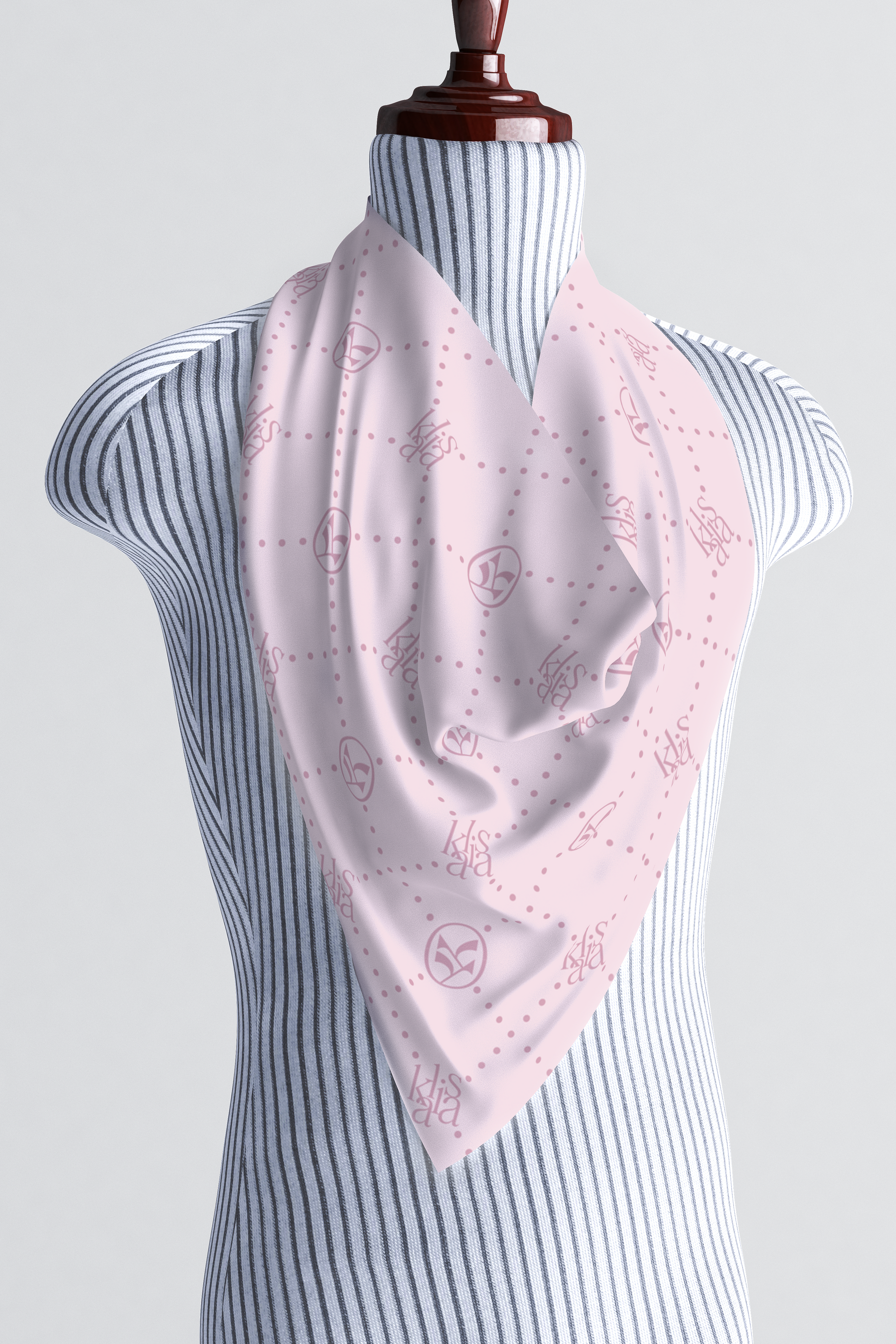 Light pink silk scarf with the "kalisa" logo tied around the neck