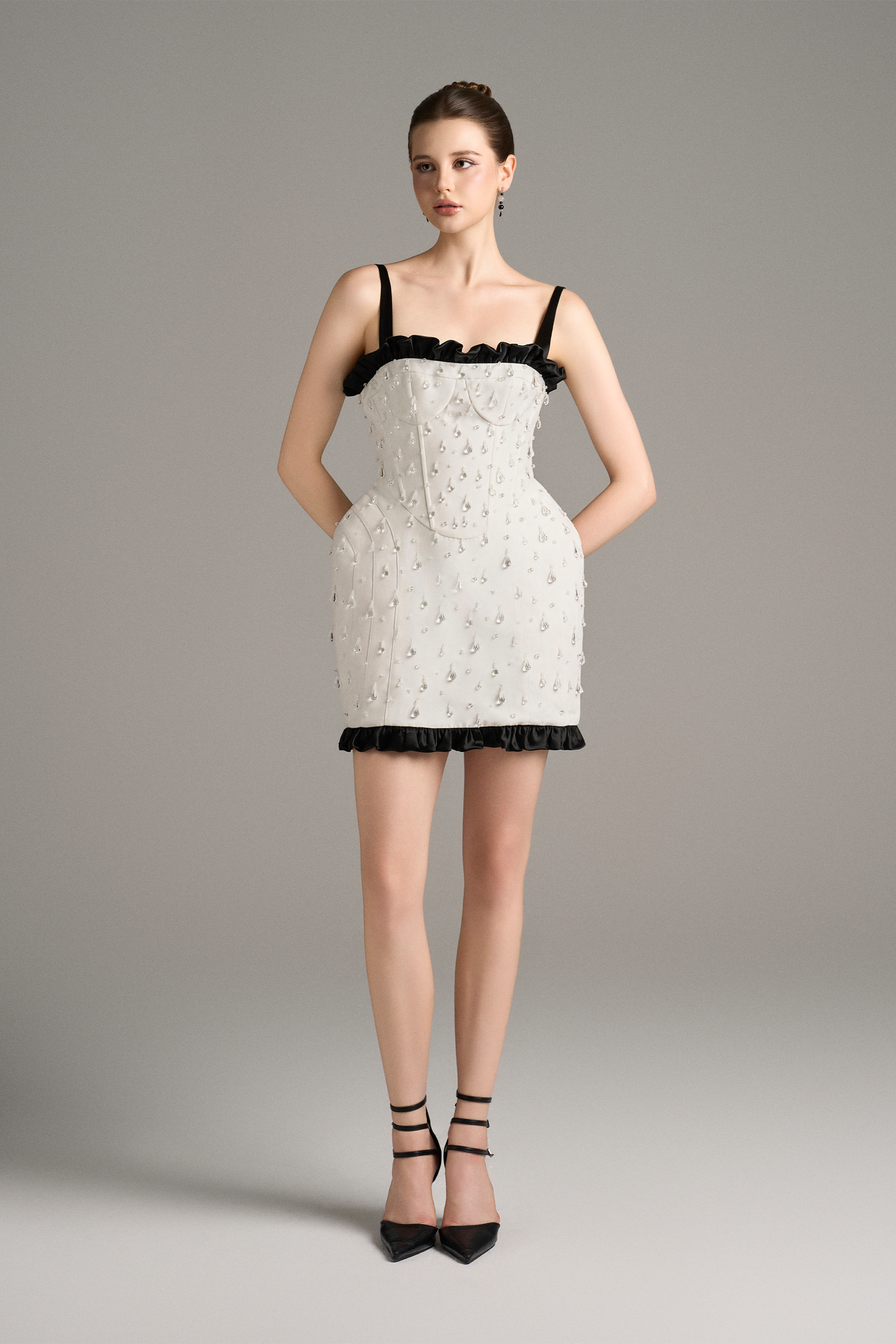 Woman wearing a white lace dress with black trim