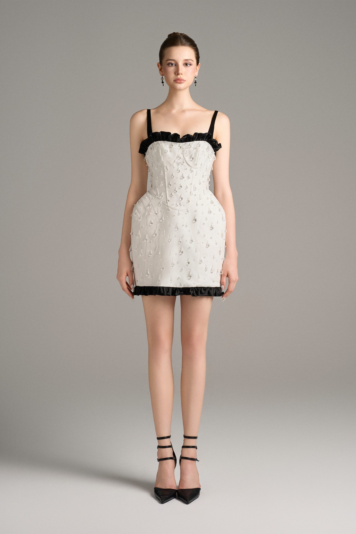 White lace dress with black trim worn by a model