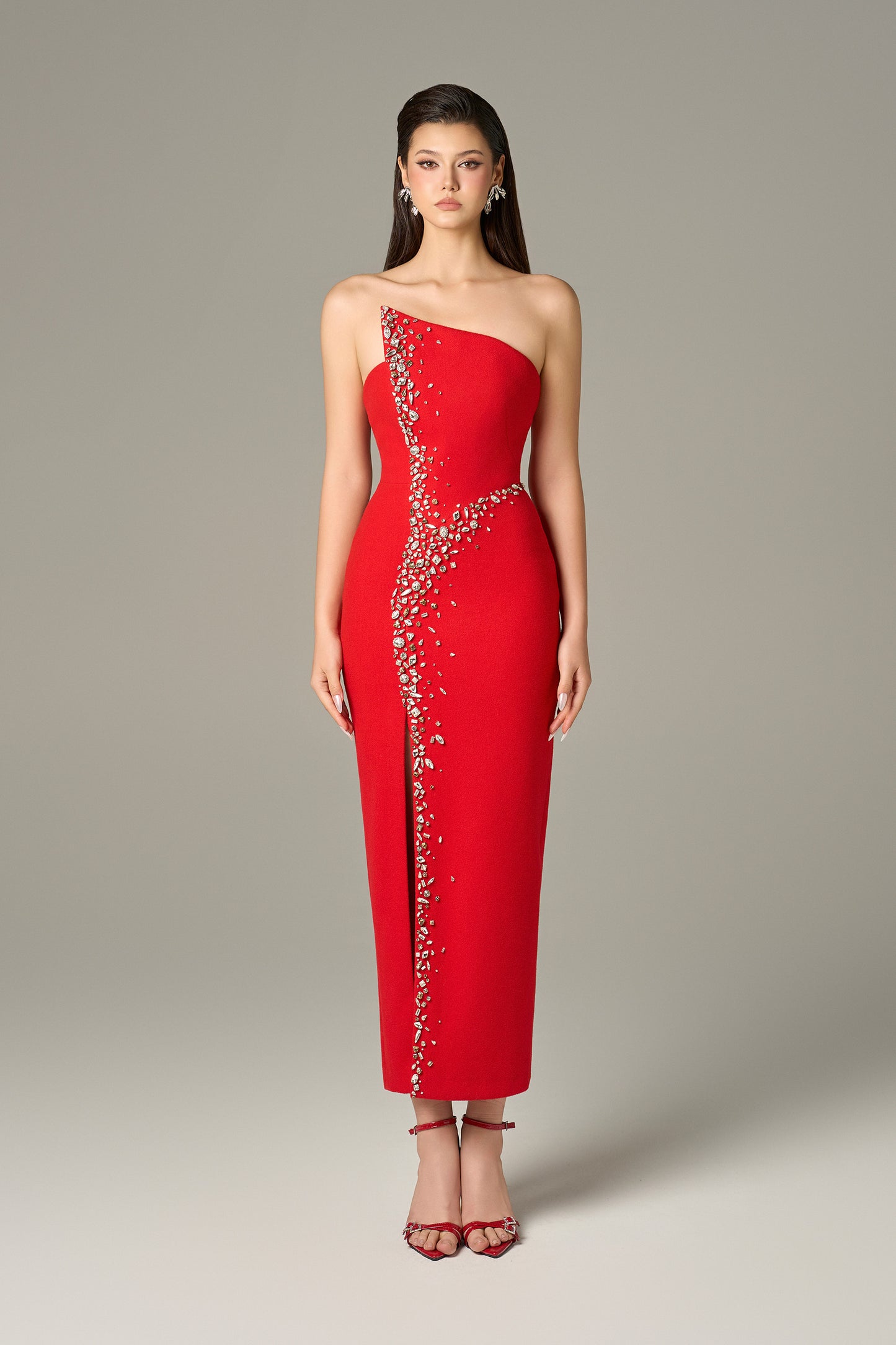 Red maxi dress in felt, with a strapless neckline, crystal embellishments and a thigh-high slit.