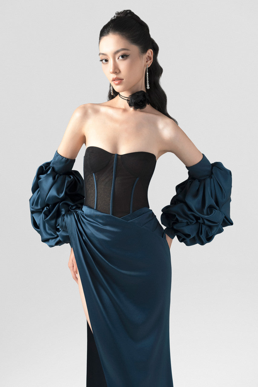 A navy blue silk dress, featuring a structured black mesh corset, detachable puffed sleeves, and a striking high slit.