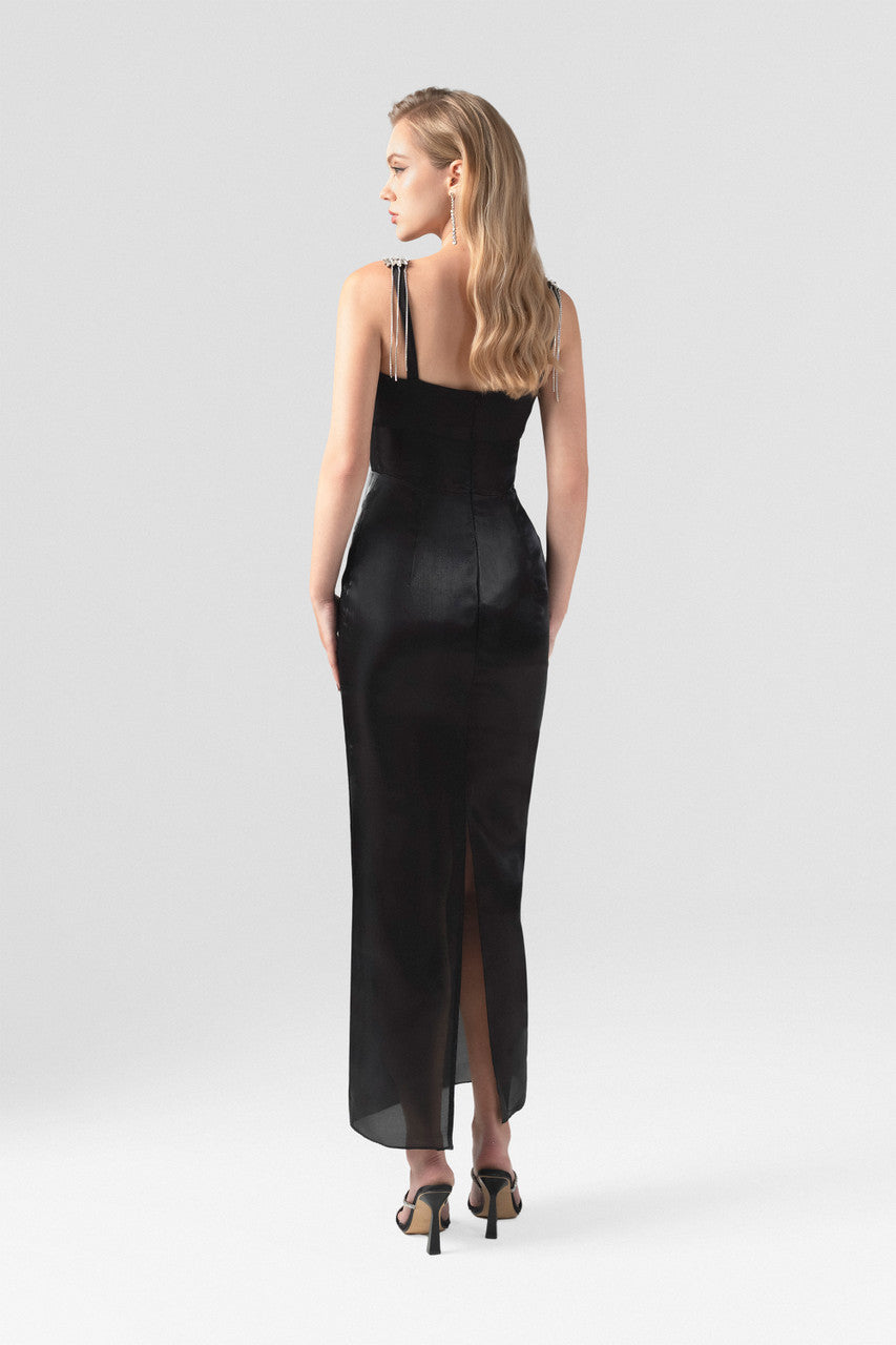 The black dress with classic square neckline, sleeveless design, and intricate orchid appliqués.