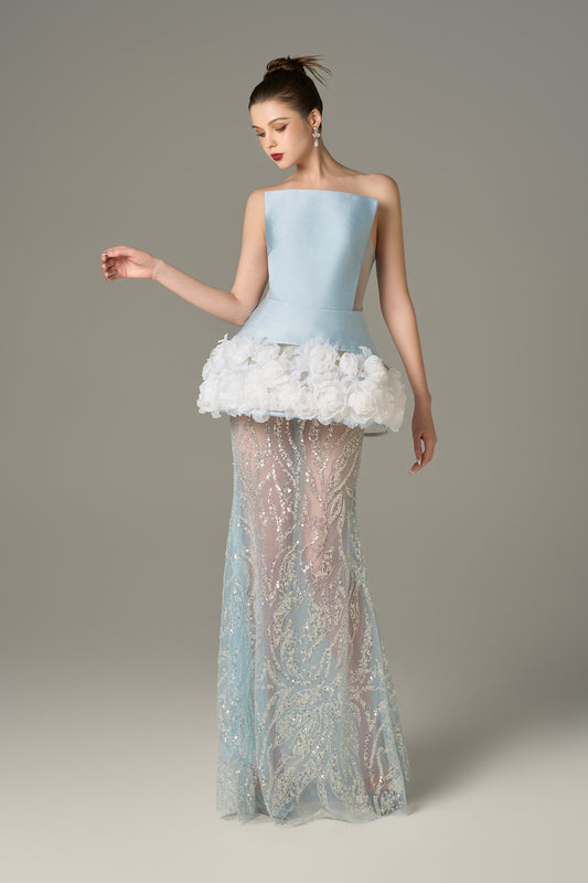 The Blue Gown stuns with a strapless bodice and shimmering lace skirt and handcrafted floral appliqués.