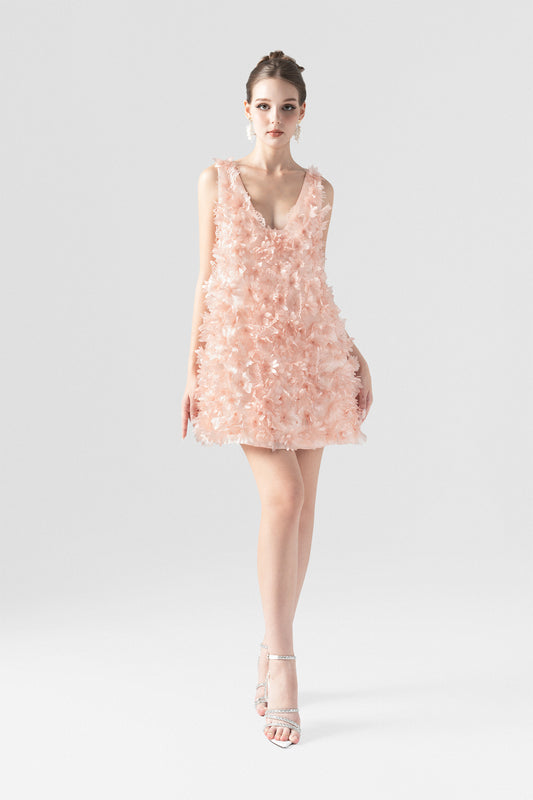A pink mini dress in organza, with an A-line silhouette and a deep open back with butterfly accent.