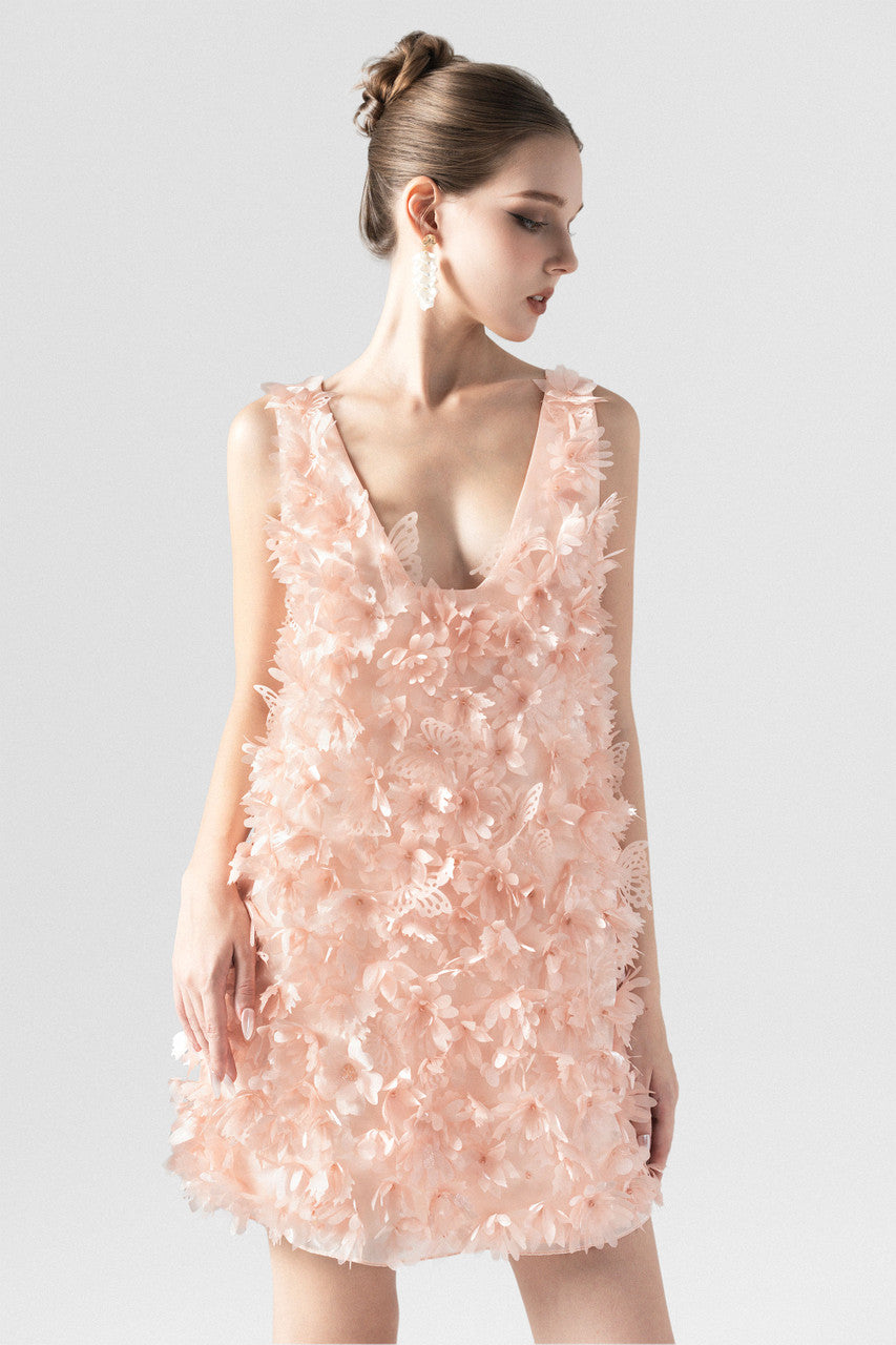 A pink mini dress in organza, with an A-line silhouette and a deep open back with butterfly accent.