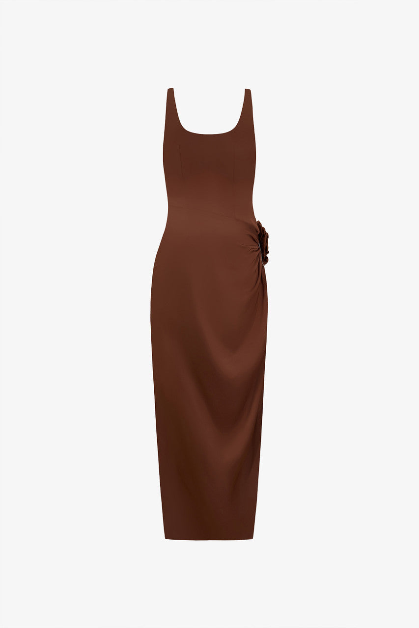 The brown silk maxi dress, detailed with a scoop neckline, hand-sewn rose accent, and stone chain embellishments.