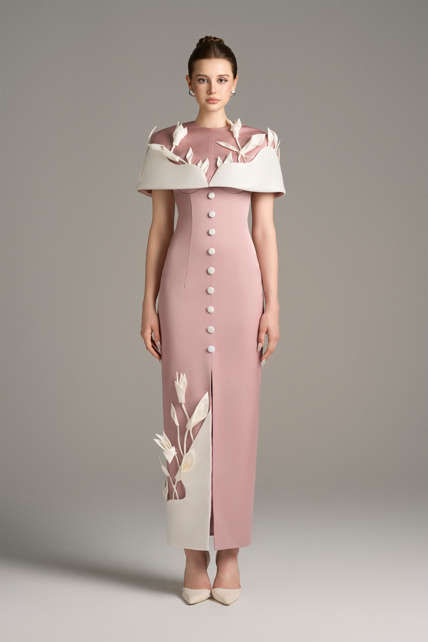 Woman wearing a pink dress with white floral details