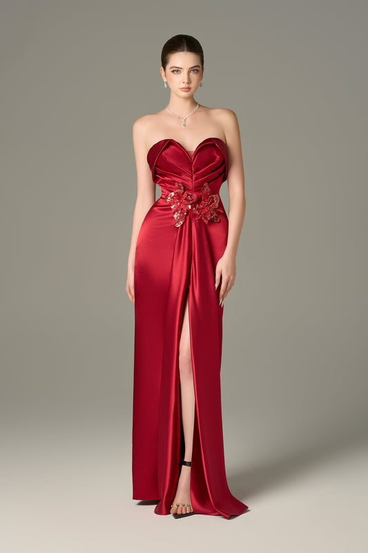The Red Satin Silk Maxi Dress stuns with a 3D pleated heart bodice, sequin floral details and a  thigh-high slit.