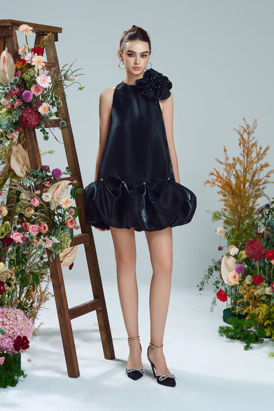 The black mini dress, featuring a oversized floral accent at the neckline and a bubble hem.