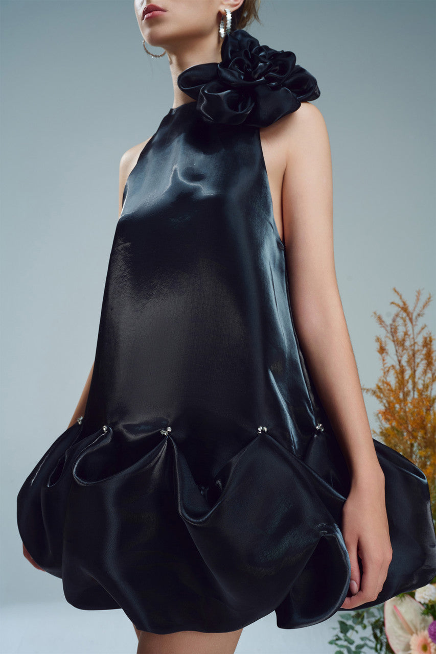 The black mini dress, featuring a oversized floral accent at the neckline and a bubble hem.
