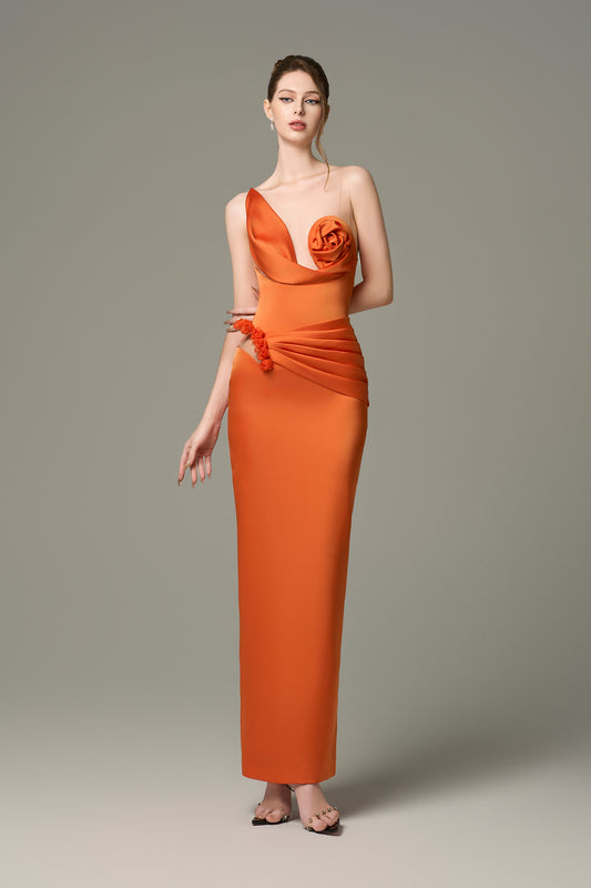 The Orange Silk Floral Bust Draped Maxi Dress features an asymmetrical floral bust and a high-slit skirt.