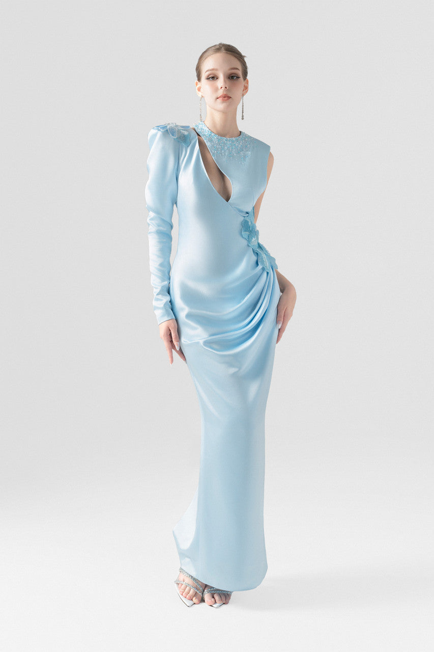 A blue silk maxi dress, with sequin floral accents and asymmetrical design.