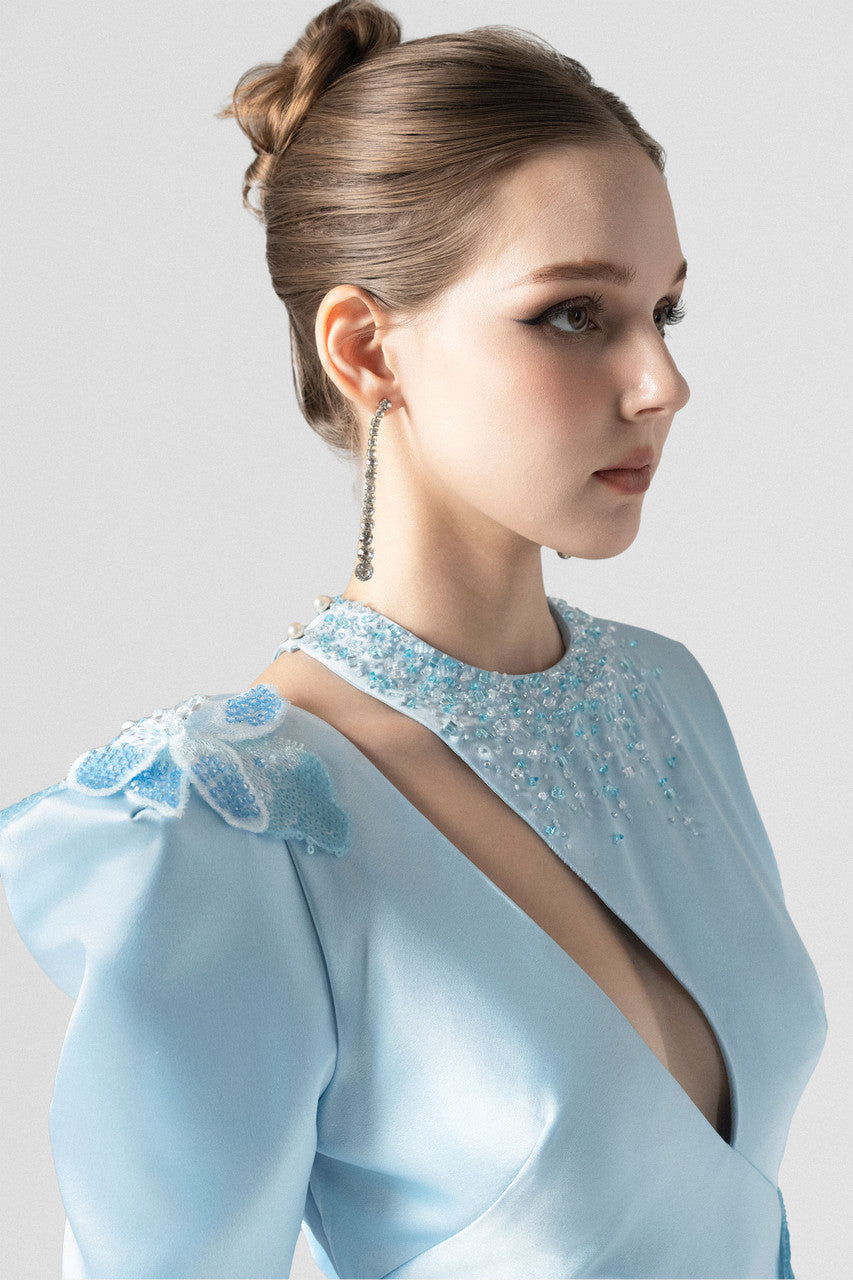 A blue silk maxi dress, with sequin floral accents and asymmetrical design.