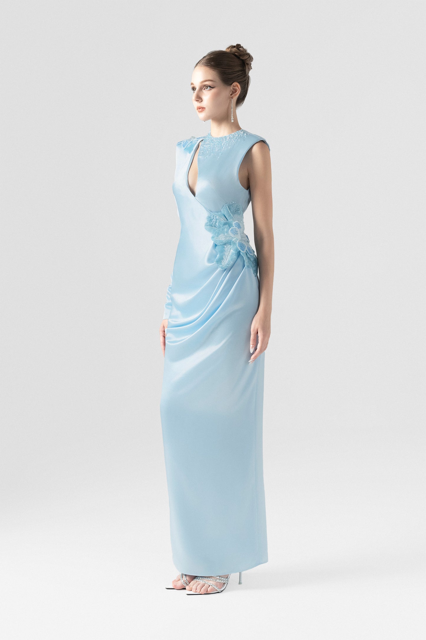 A blue silk maxi dress, with sequin floral accents and asymmetrical design.