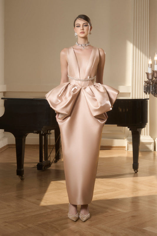 The gold evening dress in silk organza, with a deep neckline, a beaded belt, and exaggerated puffed hips.