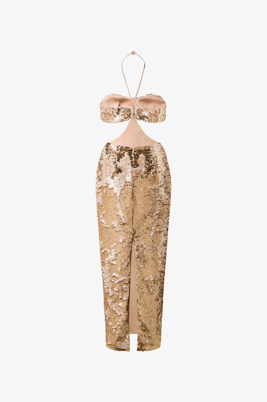 An evening dress in shimmering gold sequins. Bra-style bodice and bold cut-outs at the waist.