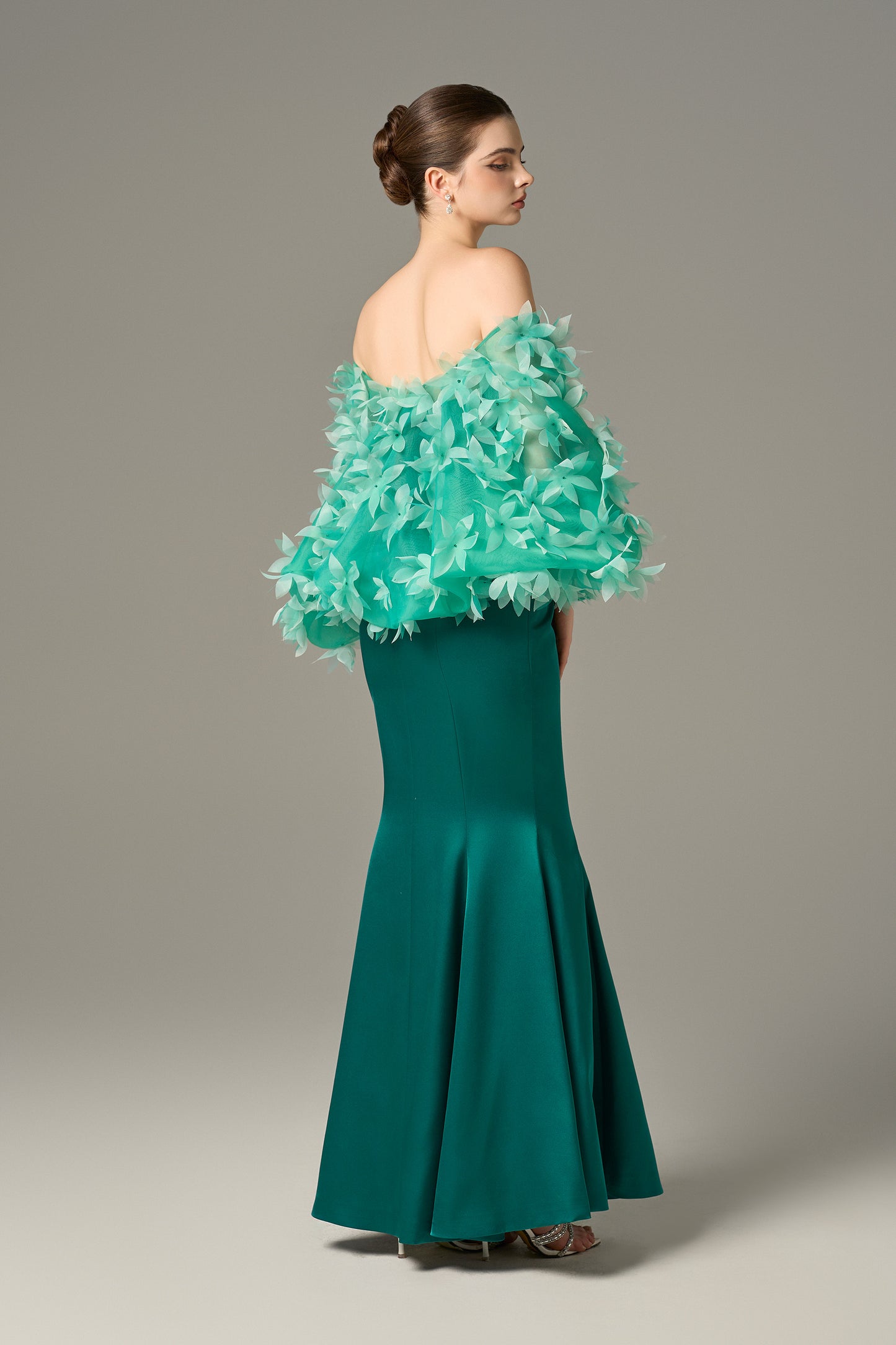 The Fishtail Gown stuns with emerald silk finish and a floral-embellished organza cape.