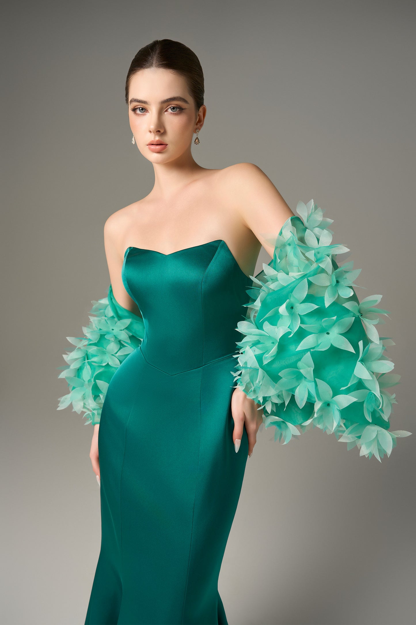 The Fishtail Gown stuns with emerald silk finish and a floral-embellished organza cape.