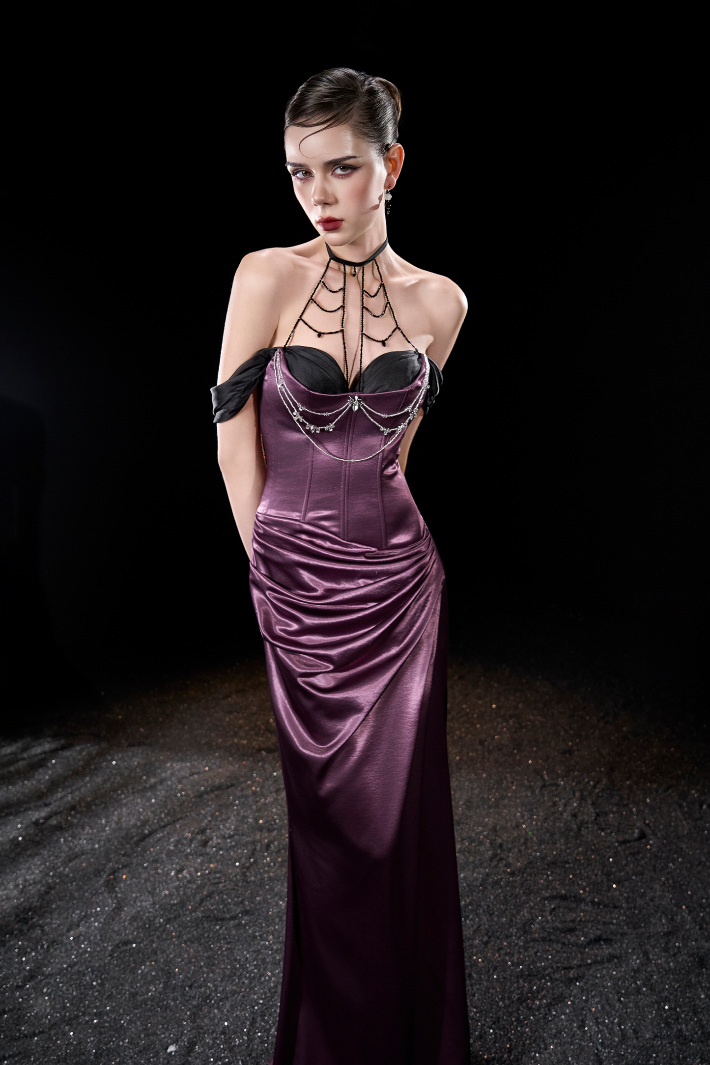 Model wearing a purple evening gown with black lace details