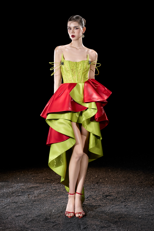 Model wearing a colorful dress with a green top and red skirt