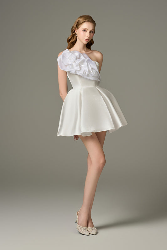 A full-length side view of a graceful white flared micro-mini dress, showcasing its fluffy skirt and the one-shoulder strap with handcrafted floral embellishments.