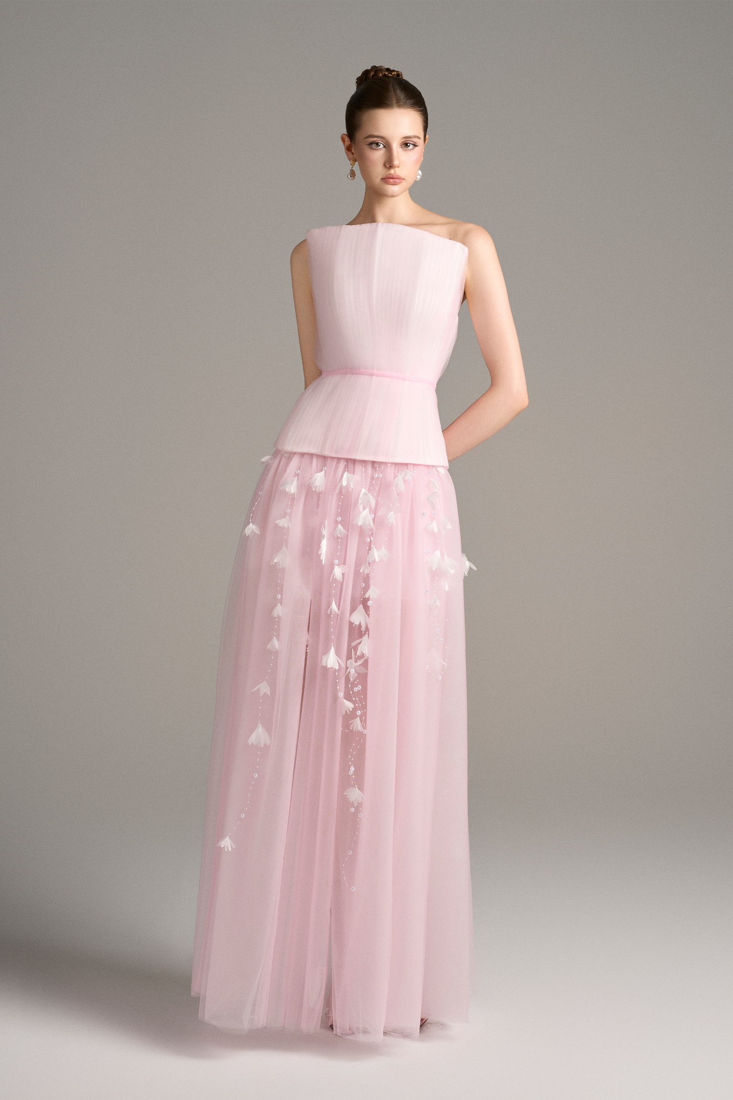 Close-up angled view of Aveta bandeau pastel pink dress set highlighting corset-style top, square neckline, and floral pearl appliqué strands on sheer maxi skirt.