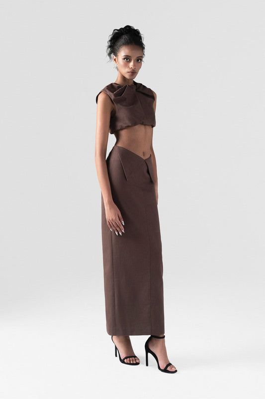 Brown khaki set, featuring a sleeveless crop top with a statement bow and a high-waisted maxi skirt.