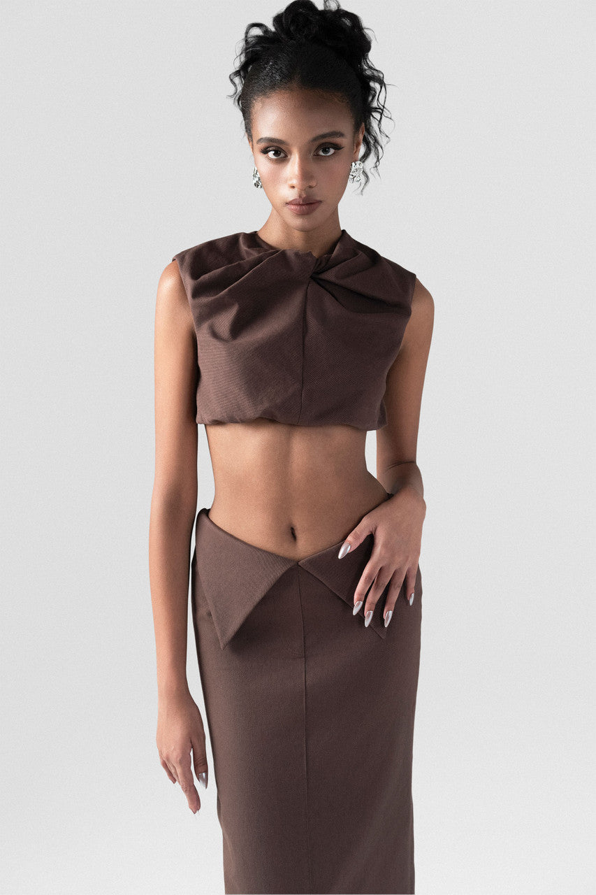 Brown khaki set, featuring a sleeveless crop top with a statement bow and a high-waisted maxi skirt.
