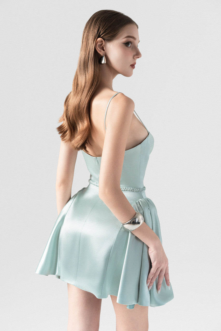 The green silk mini dress with woven tie detail around the waist, sleek spaghetti straps and slightly flared skirt.