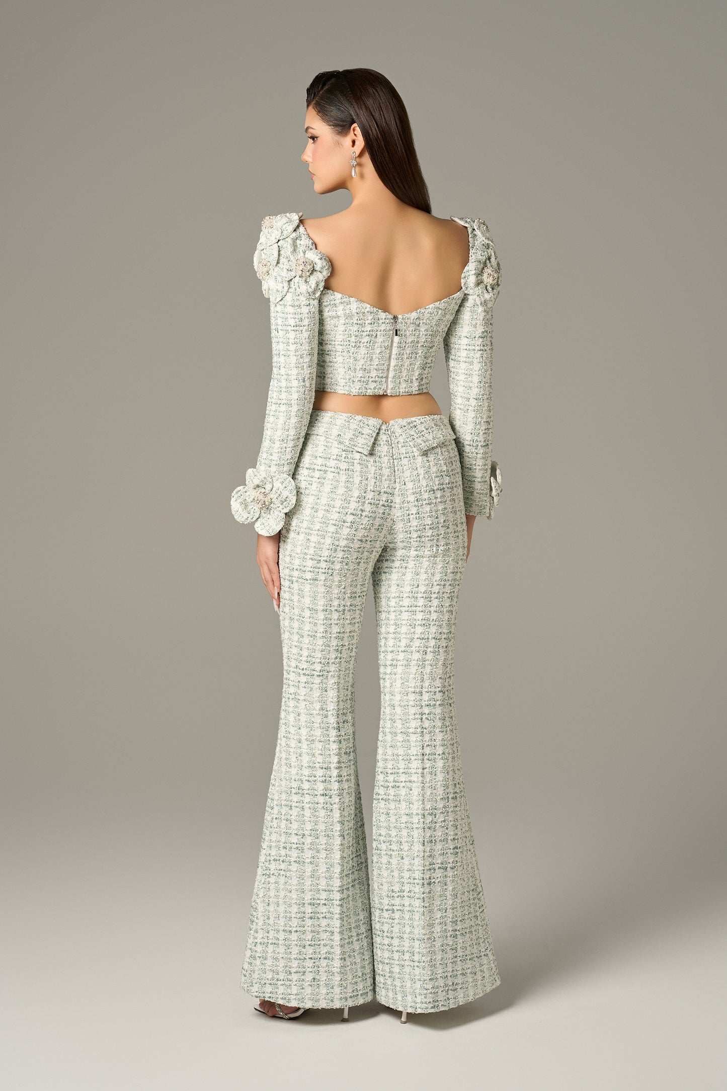 a set in mint green tweed, with a crop top and high-waisted flared trousers.