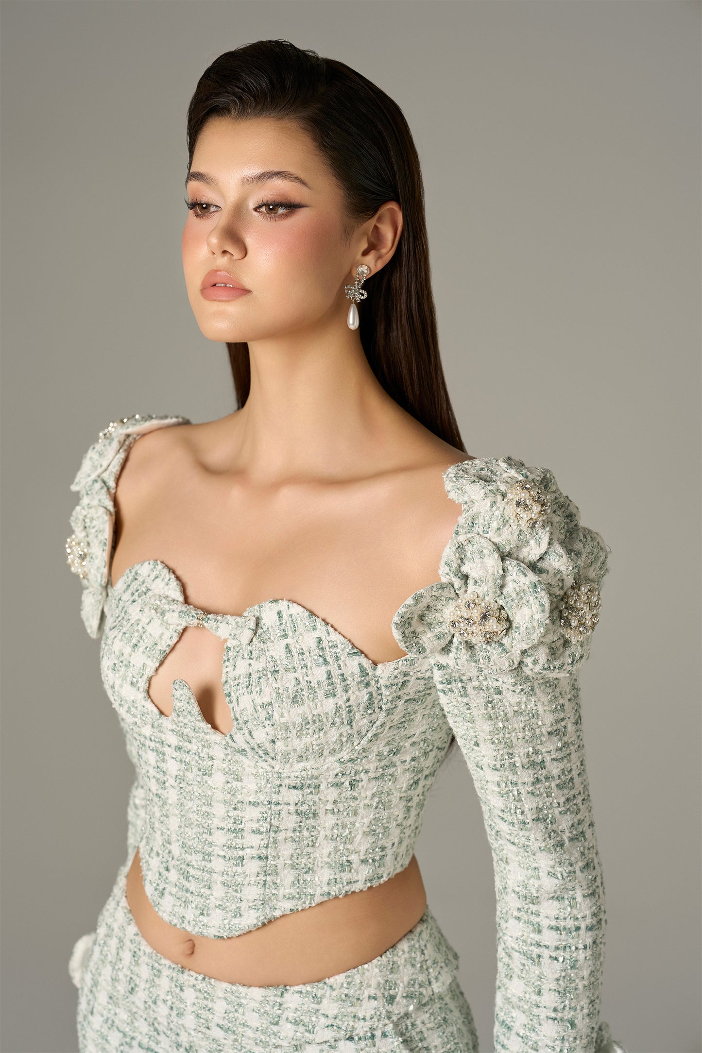 a set in mint green tweed, with a crop top and high-waisted flared trousers.