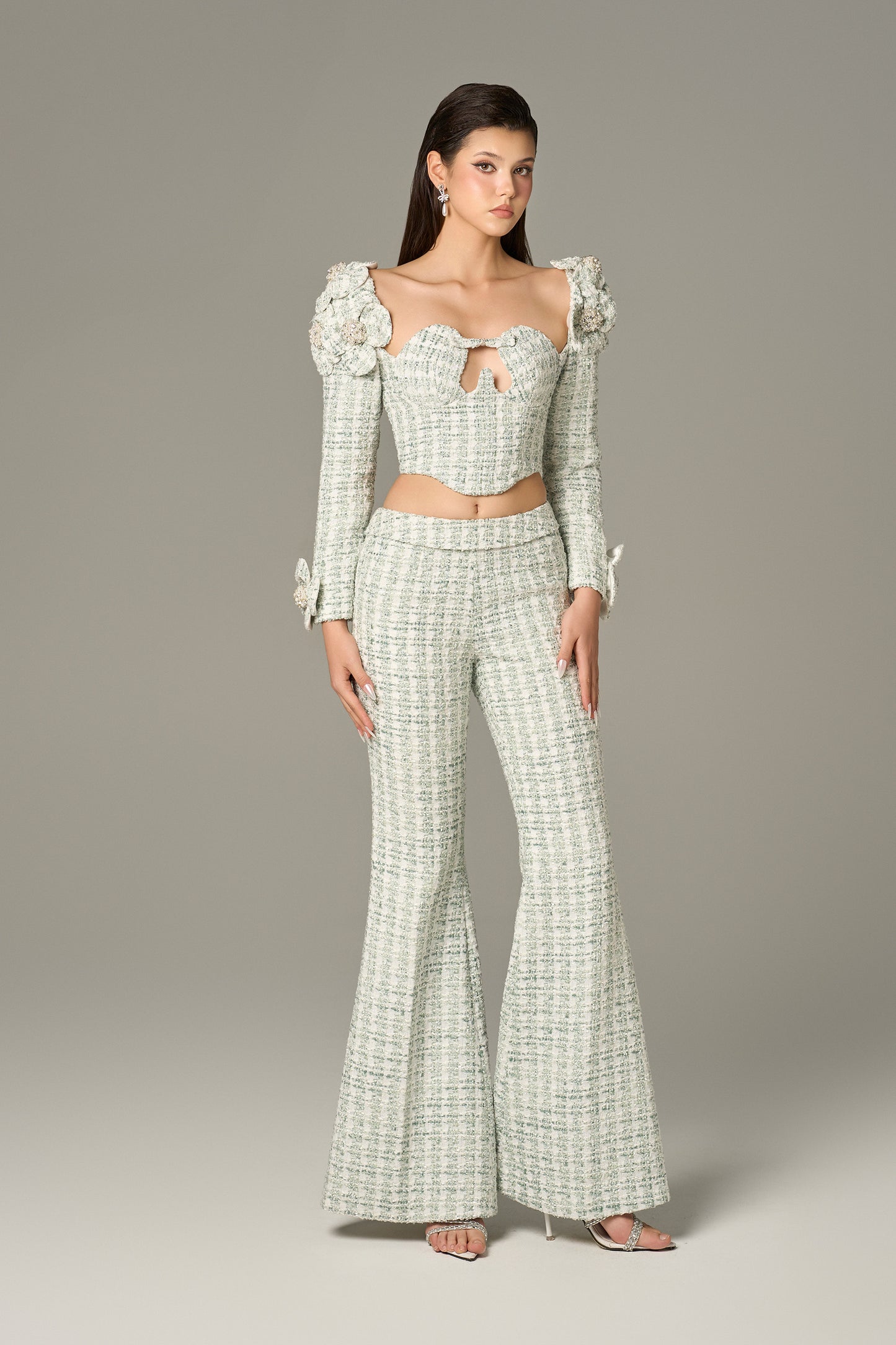 a set in mint green tweed, with a crop top and high-waisted flared trousers.