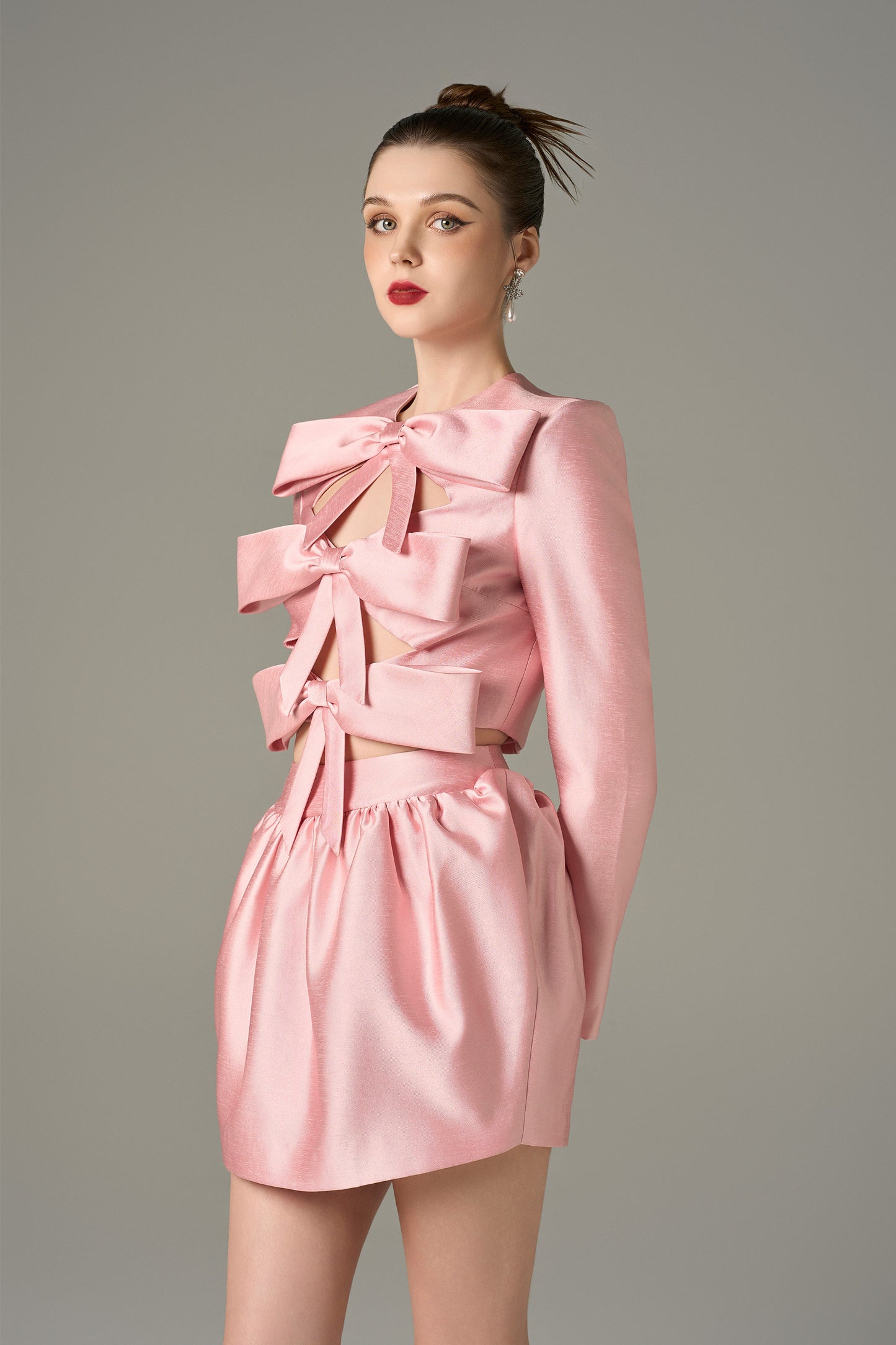 The Pink Cutout Tiered Mini Dress with oversized bows, chic cutouts, and a voluminous skirt.