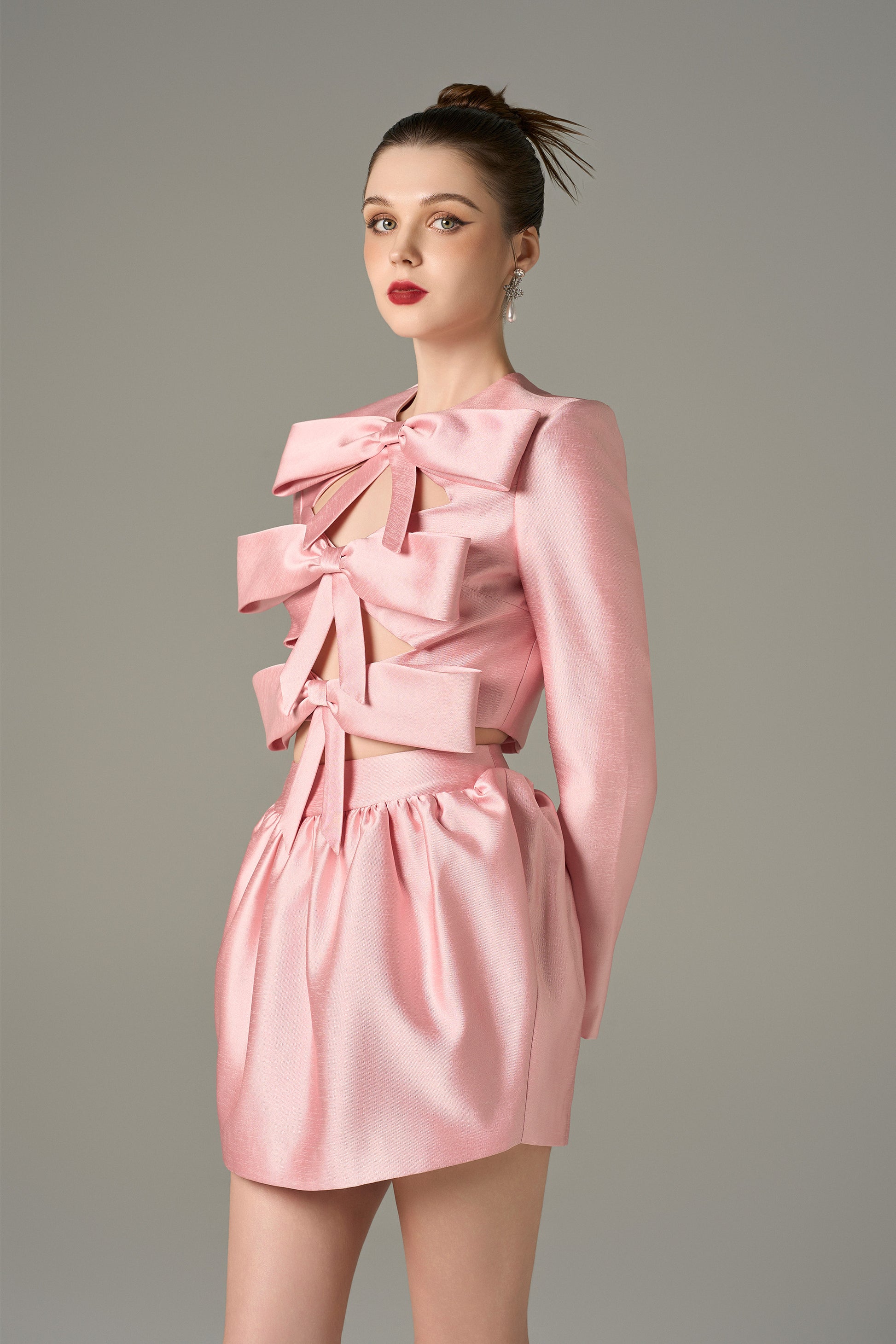 The Pink Cutout Tiered Mini Dress with oversized bows, chic cutouts, and a voluminous skirt.