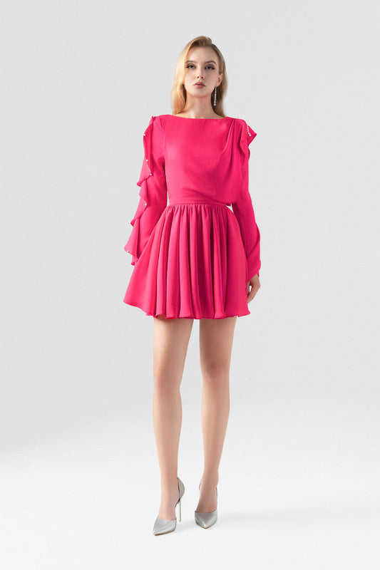 The pink silk mini dress, featuring daring open-back design, flowing pleats and ruffled detailing.