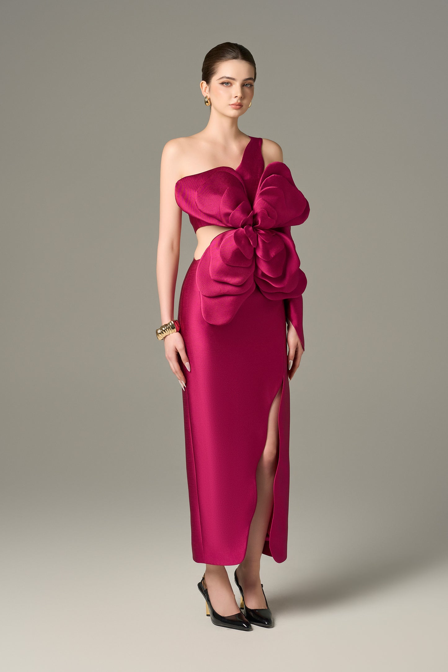 Pink Maxi Dress features an asymmetrical one-sleeve design with layered floral details and a thigh-high slit.