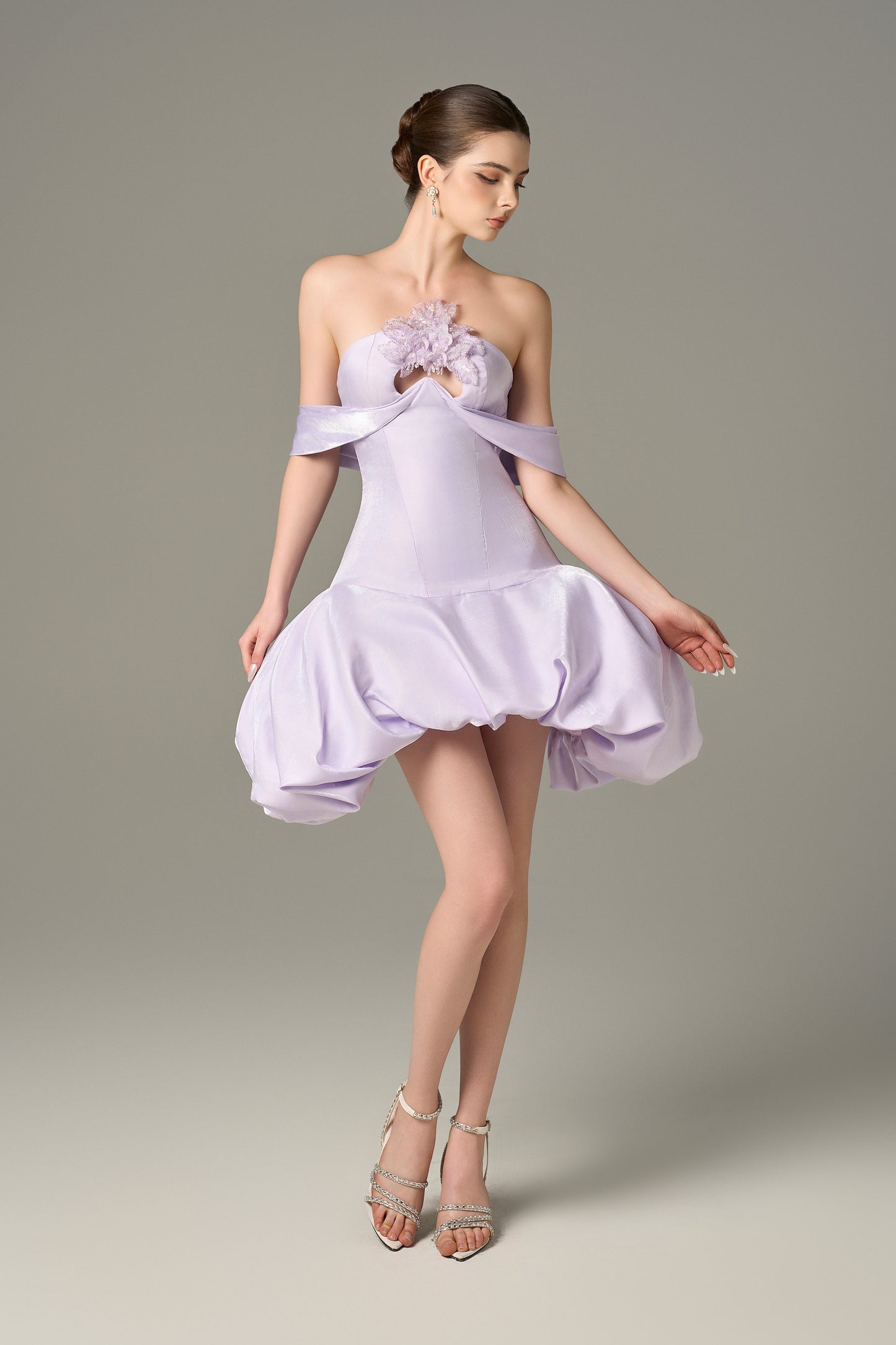 The Purple Mini Dress stuns with off-shoulder draped straps, a voluminous puff skirt and sequin floral details.
