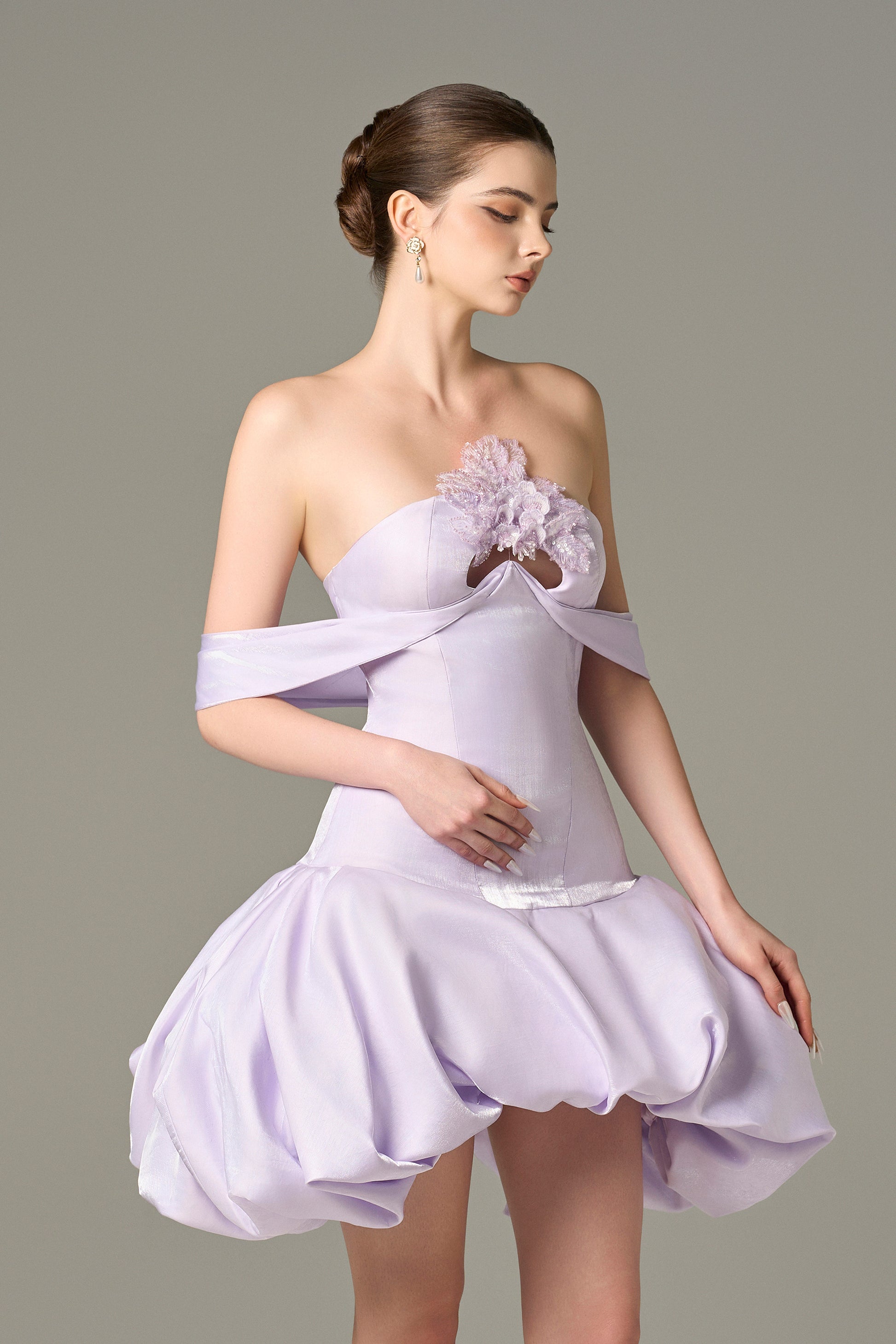 The Purple Mini Dress stuns with off-shoulder draped straps, a voluminous puff skirt and sequin floral details.