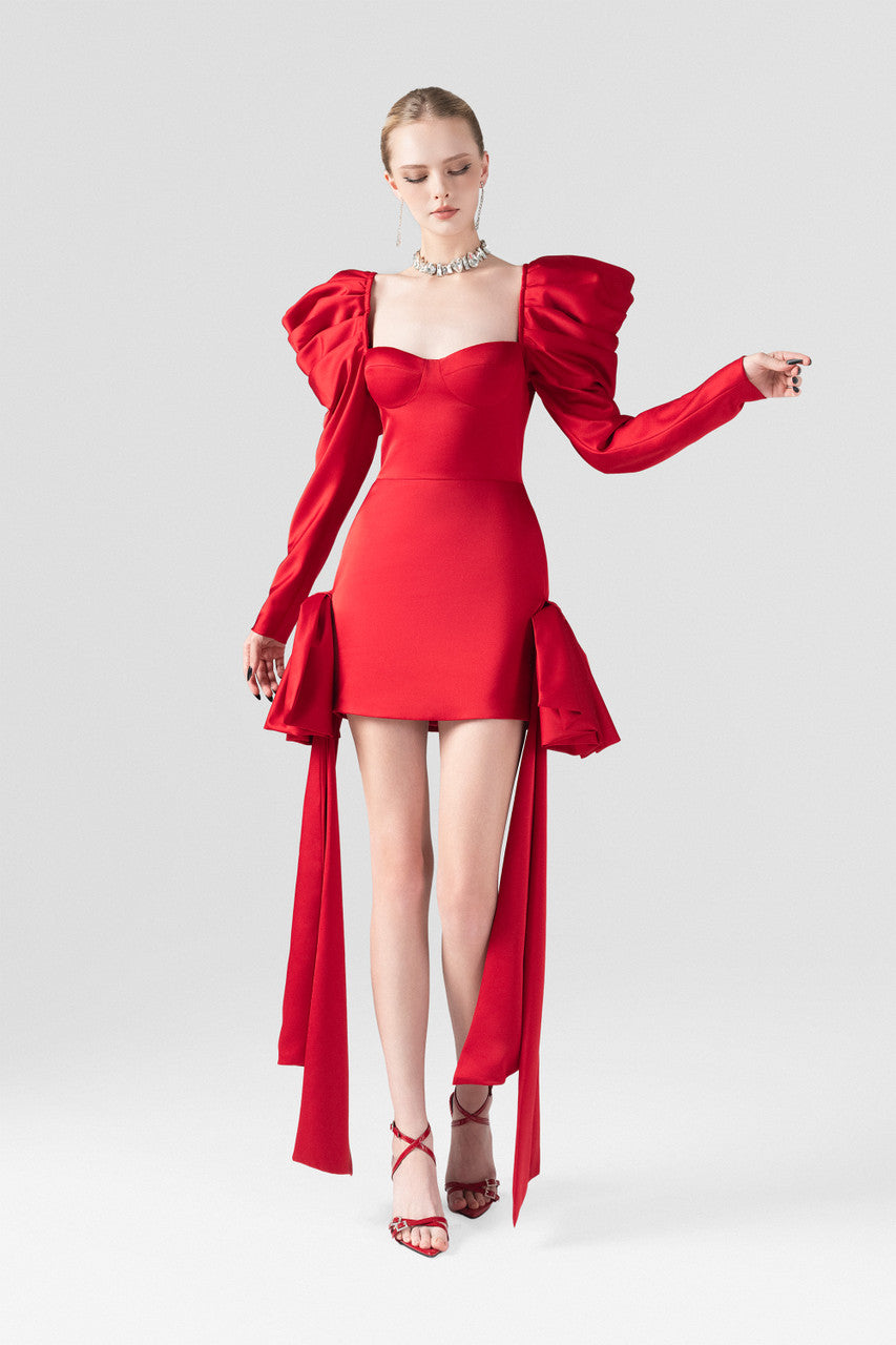The red silk mini dress, with bust cup bodice, puffed sleeves and two crafted bows at the hips.