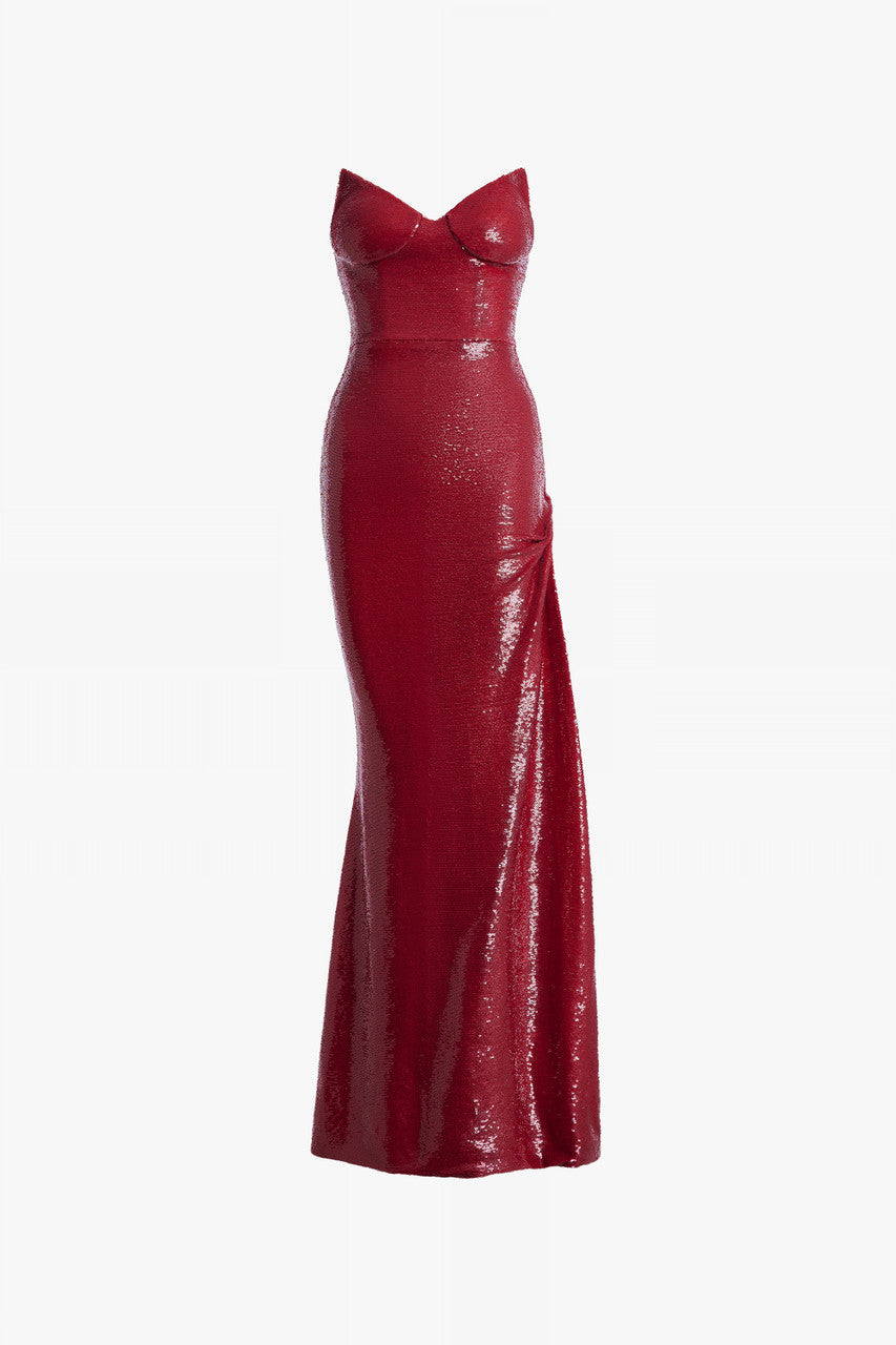 Red evening dress in sequin, with a cat-eye neckline and a thigh-high slit with ruffled details.