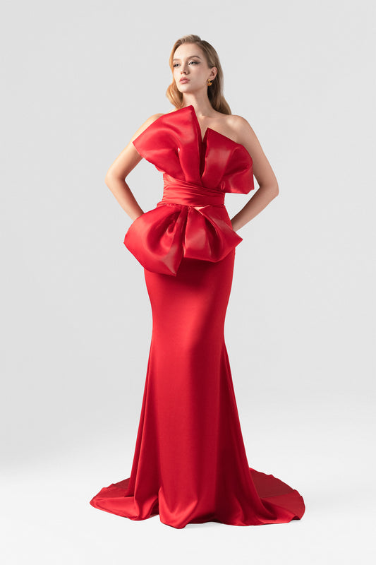 The red silk evening dress, featuring a fishtail silhouette and an oversized bow.