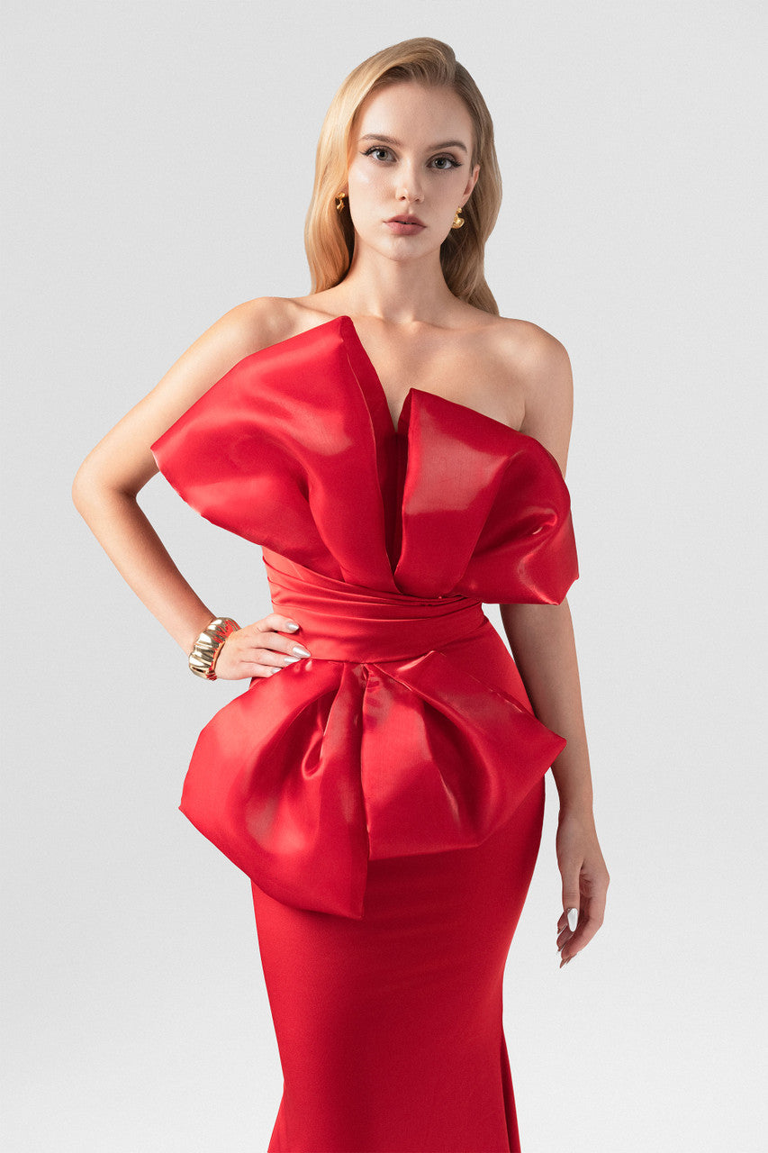 The red silk evening dress, featuring a fishtail silhouette and an oversized bow.