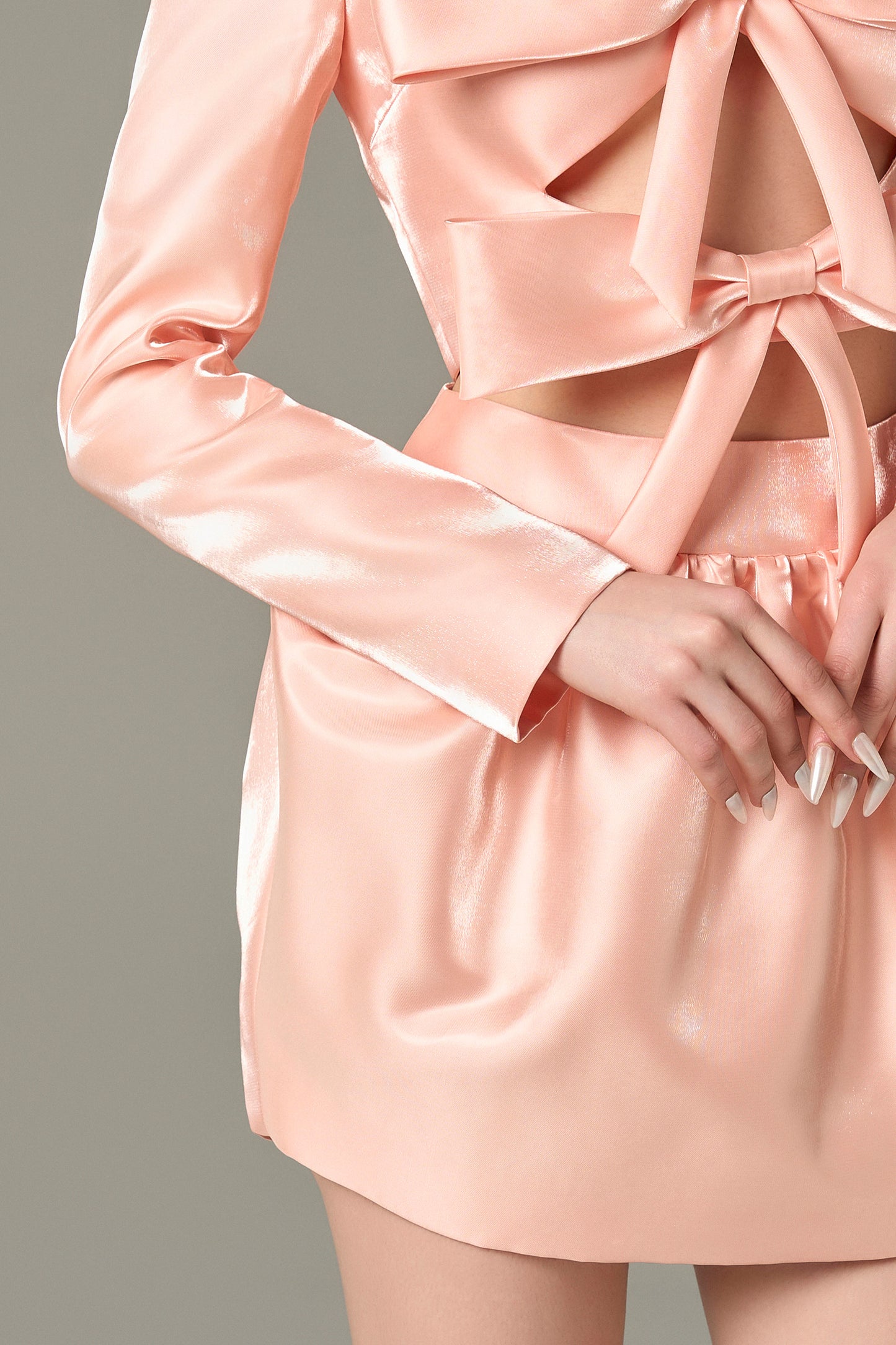The Salmon Pink Bow Accent Cutout Mini Dress with oversized bows, chic cutouts, and a voluminous skirt.