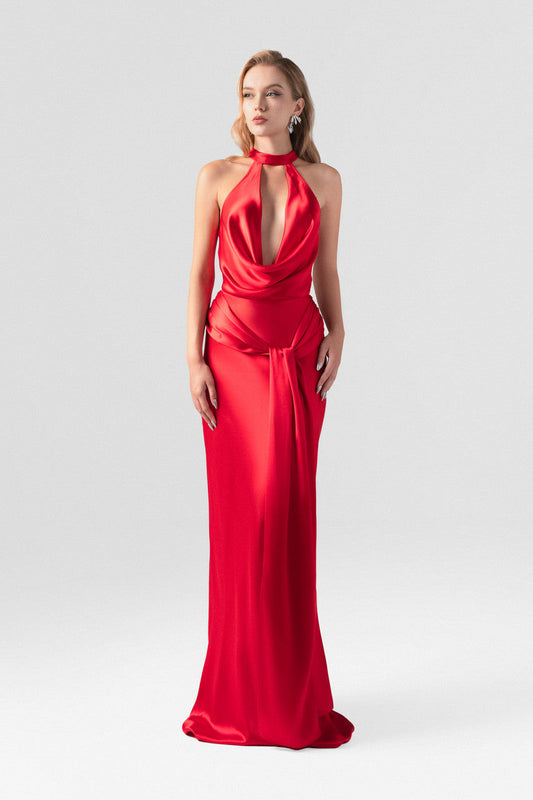 Red evening dress in silk with plunging neckline, sleeveless halter design.