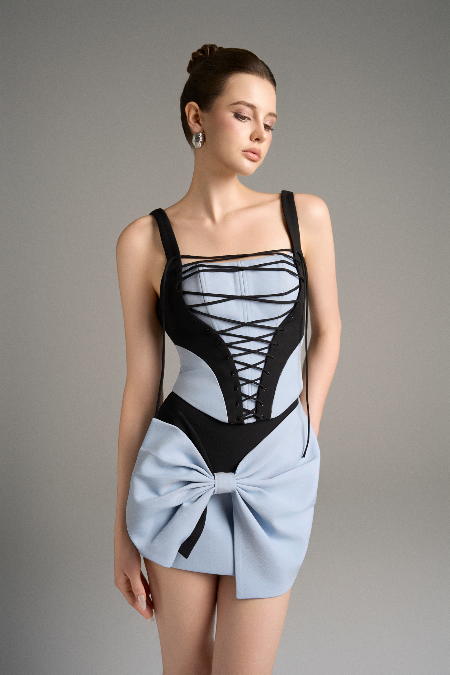 Woman wearing a black and blue dress with a bow detail