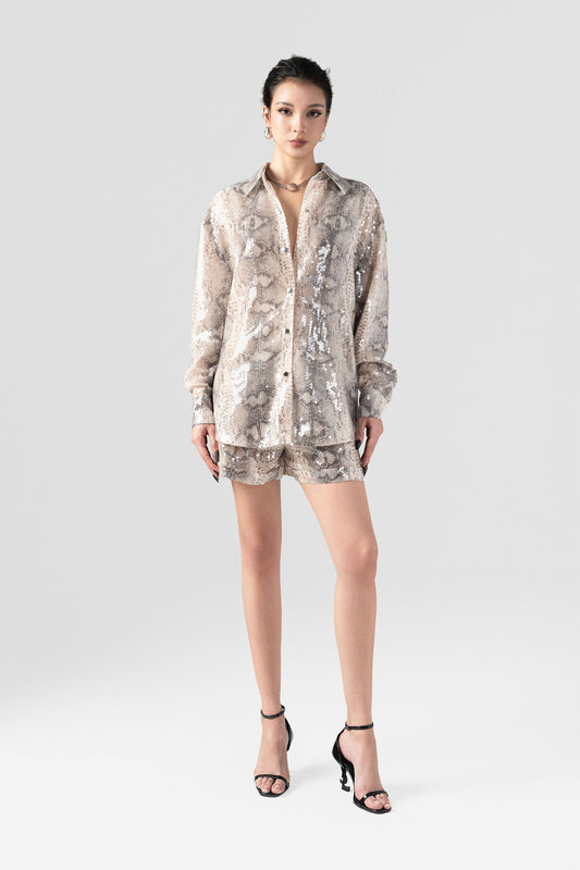 A sequin oversized shirt paired with snakeskin beige shorts.