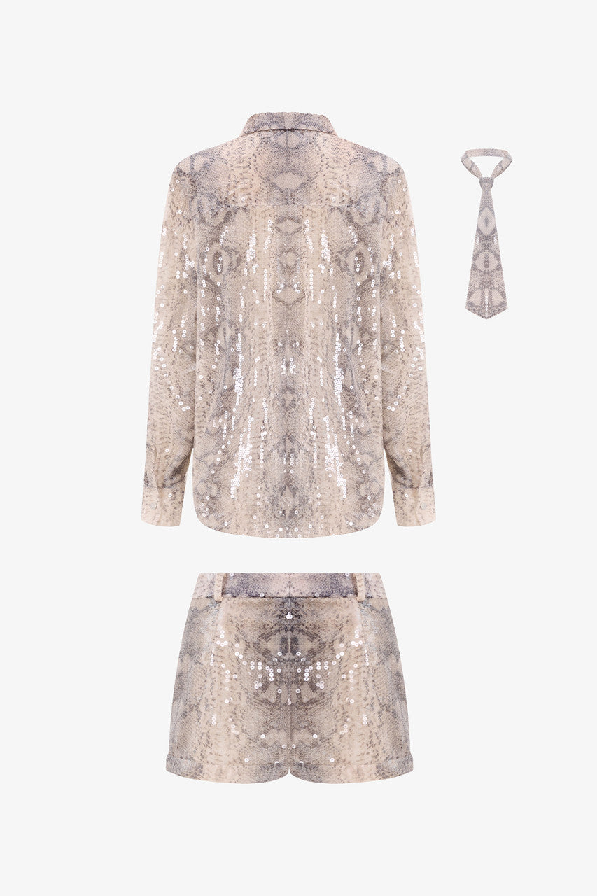 A sequin oversized shirt paired with snakeskin beige shorts.