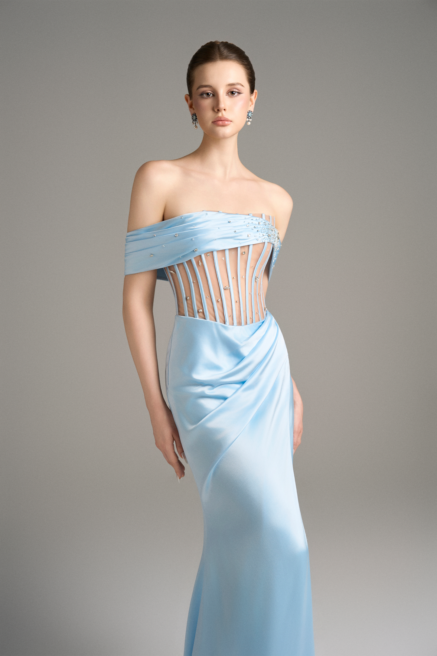 Back view highlighting the fluid train and refined tailoring of the sky-blue off-shoulder corset gown.